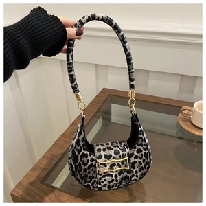 Close-up of leopard print hobo bag with elegant gold hardware on a wooden table