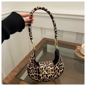 Detailed view of leopard print crescent bag with gold chain and hardware held by hand
