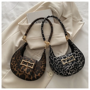 Detail of leopard print underarm bags with gold geometric buckles on cream blazer