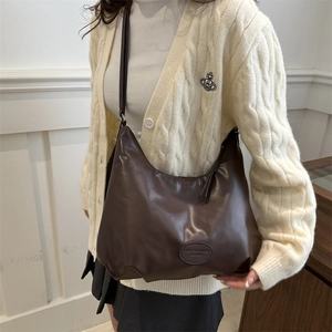 Classic dark brown leather tote bag worn by model in a chic french style fashion setting