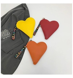 Close-up of heart-shaped clutches in yellow, red, and orange with Love wristlet
