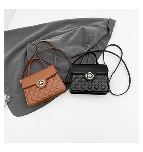 Close-up of quilted PU leather texture and golden flower clasp on brown and black handbags