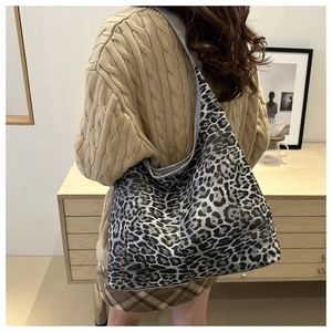 Detail view of large leopard print tote bag styled with cozy winter sweater outfit