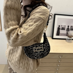 Chic leopard print crescent shoulder bag with golden buckle shown on a model