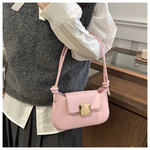 Dettaglio della borsa sottobraccio rosa con fibbia in metallo oro e tracolla annodata