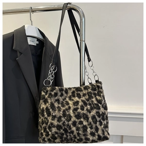 Detail of plush leopard print faux fur texture with silver metal chain strap on tote bag