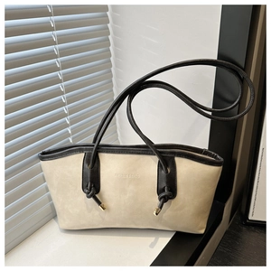 Detail of off-white tote bag with black contrast piping and long knotted shoulder straps
