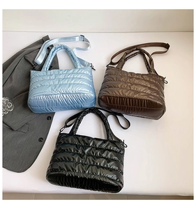 Three padded quilted puffer tote bags in blue, brown and black with shiny finish