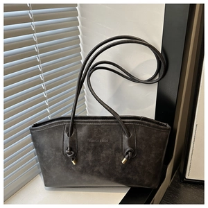 Detail of black faux leather tote with FASHION & BAGS embossing and knotted straps