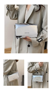 Gros plan du sac à bandoulière argenté brillant avec chaîne et logo Sunita & Fashion