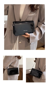 Détail du sac à bandoulière en cuir verni noir brillant avec chaîne argentée et logo