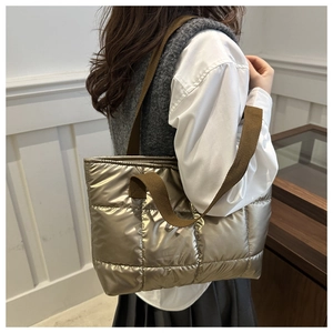 Sac fourre-tout matelassé bronze métallisé porté avec une tenue décontractée chic