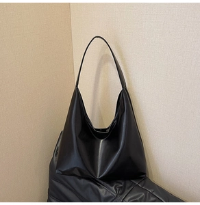 Macro detail of high-quality black PU leather texture on a minimalist large tote bag