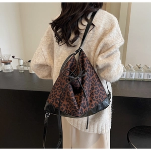 Vue détaillée du sac cabas léopard avec nœud en cuir à cordon et texture noire élégante