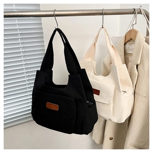 Dettaglio di borse tote in nylon con patch 'FASHION' e pratica tasca frontale