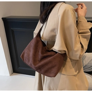 Detail showing soft suede texture and leather strap of the dark brown hobo bag