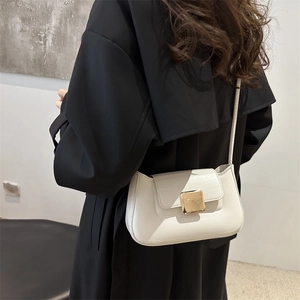 Borsa a spalla in pelle crema con fibbia dorata quadrata indossata su cappotto nero