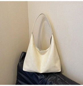 Detail of minimalist cream beige hobo bag with matte faux leather texture and moon shape
