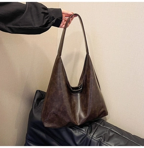 Detail of dark brown faux leather tote with vintage texture and slouchy hobo design