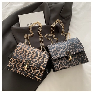 Close-up of leopard print crossbody bags with gold chain straps and metal oval buckles