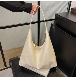 Detailed view of the creamy white PU leather hobo bag with a minimalist wide strap