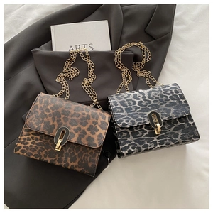 Flat lay of two leopard print crossbody bags with gold chains and vintage clasps