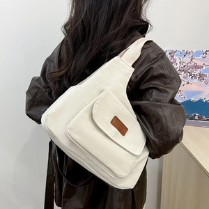 Sac fourre-tout minimaliste en toile beige avec écusson en cuir et large bandoulière