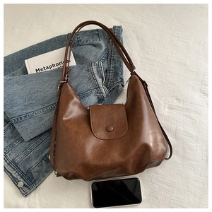 Borsa hobo vintage marrone mostrata con uno smartphone per indicarne la capacità media