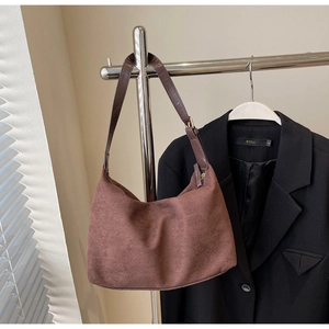Detail of coffee brown hobo bag with smooth suede texture and adjustable leather strap