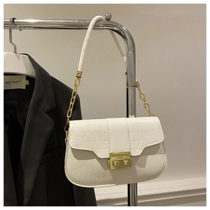 Detail of white crocodile pattern PU leather bag with gold buckle on a hanger