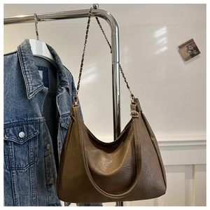 Détail du sac hobo marron montrant la texture du similicuir et la bandoulière en chaîne