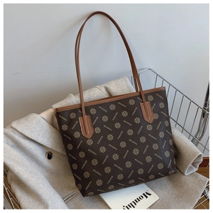 Dettaglio della grande borsa shopper stampata con lunghi manici in pelle nel carrello