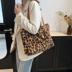 Chic leopard print plush tote bag with leather straps on a white blazer outfit