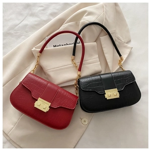 Detail of red and black crocodile embossed texture shoulder bags with gold chain straps