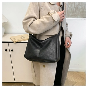 Chic black tote bag with pleated texture shown on model for a trendy casual commute