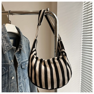 Detail of striped canvas tote bag showing thick fabric texture and wide shoulder strap