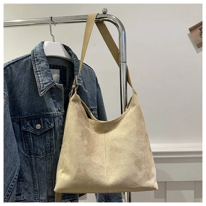 Macro shot of large capacity beige suede tote bag showing soft matte texture and shoulder strap