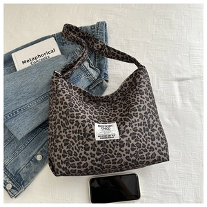 Gros plan du sac cabas en nylon à imprimé léopard avec étiquette tissée sur fond blanc