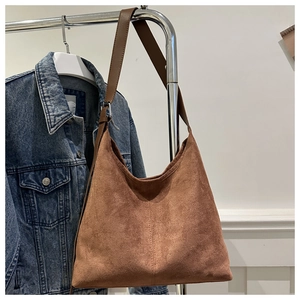 Detail view of brown matte suede hobo bag with vertical stitching and adjustable strap