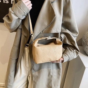 Beige woven leather crossbody pillow bag with top handle and fine shoulder strap