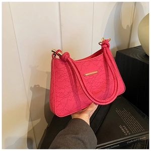 Close-up of elegant rose pink lace handbag with woven rope handles and gold metallic trim