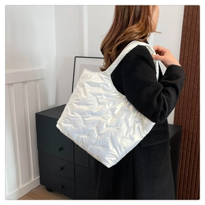 Détail du grand sac cabas blanc matelassé avec surpiqûres en V et finition nacrée élégante