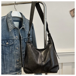 Detail der mattschwarzen Hobo-Tasche mit Quasten-Reißverschluss und vertikaler Ziernaht