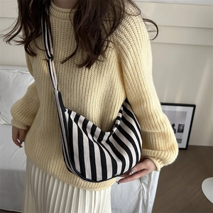 Minimalist black and white striped canvas crossbody bag in a stylish half-moon shape