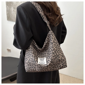 Détail du sac cabas en nylon à motif léopard avec bandoulière réglable porté par un mannequin