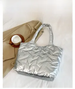 Détail de ce grand sac cabas argenté matelassé avec texture brillante effet doudoune