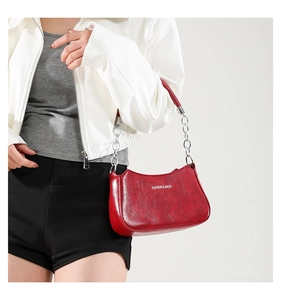 Close-up of a red leather crescent hobo bag featuring silver chain and leather strap