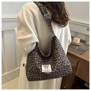 Vue détaillée du sac cabas en nylon léopard avec large bandoulière et étiquette blanche