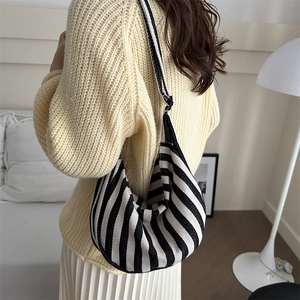 Striped knit hobo bag with a minimalist crescent design shown on a person