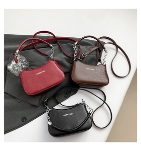 Detailed display of crescent bags in red, brown, and black with dual strap options